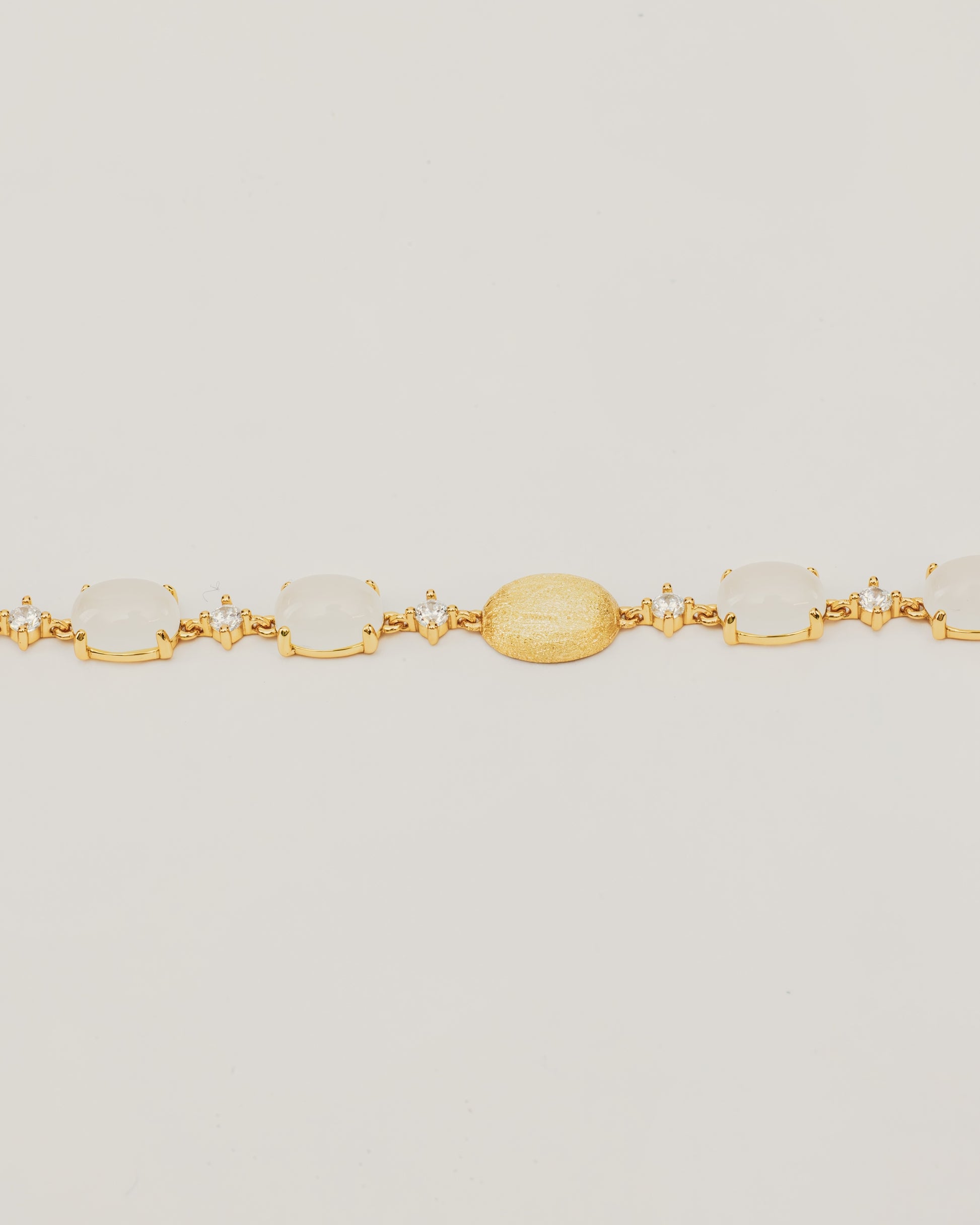 Bracciale Dorato con Pietre Cabochon Bianche e Dettagli Luminosi