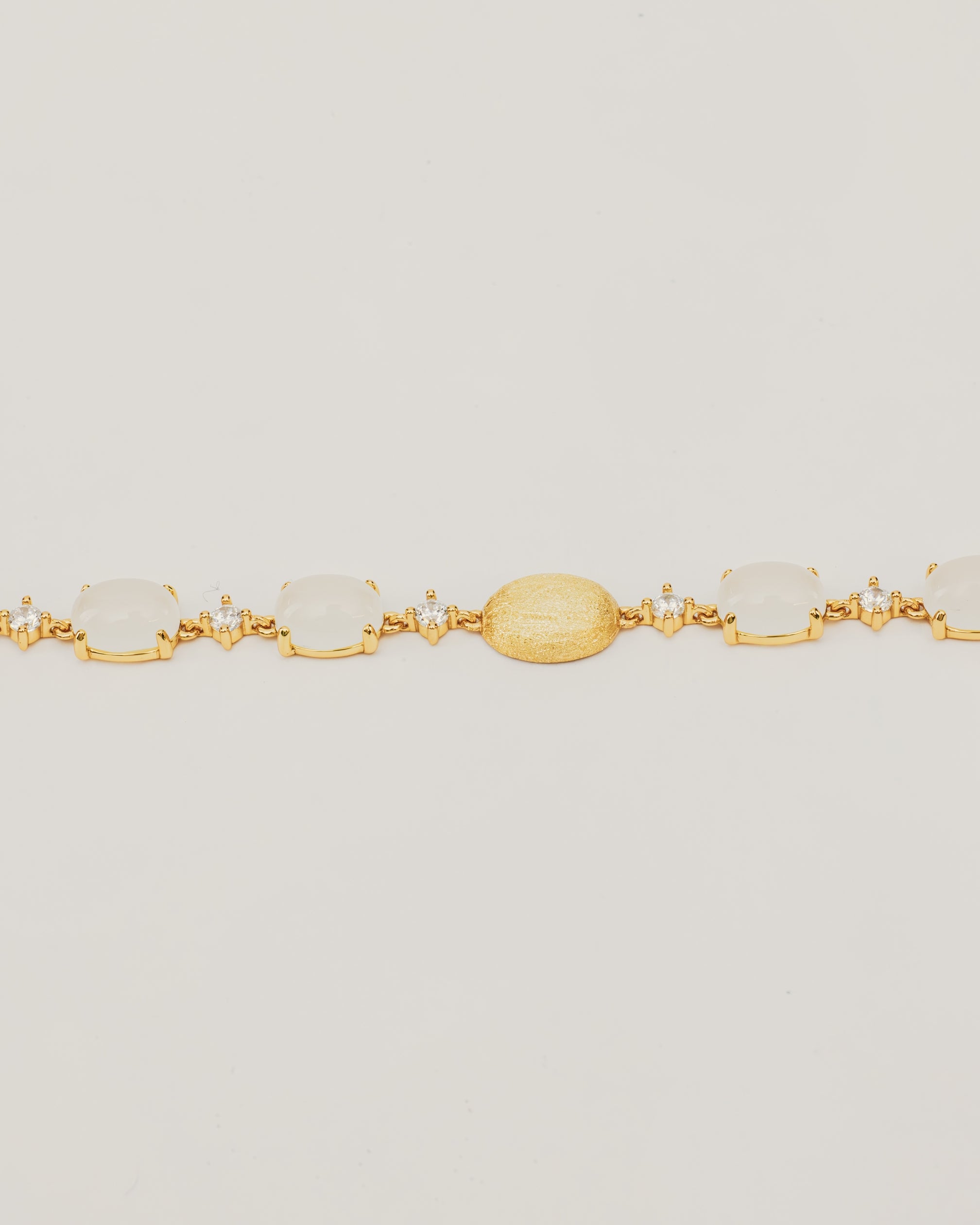 Bracciale Dorato con Pietre Cabochon Bianche e Dettagli Luminosi