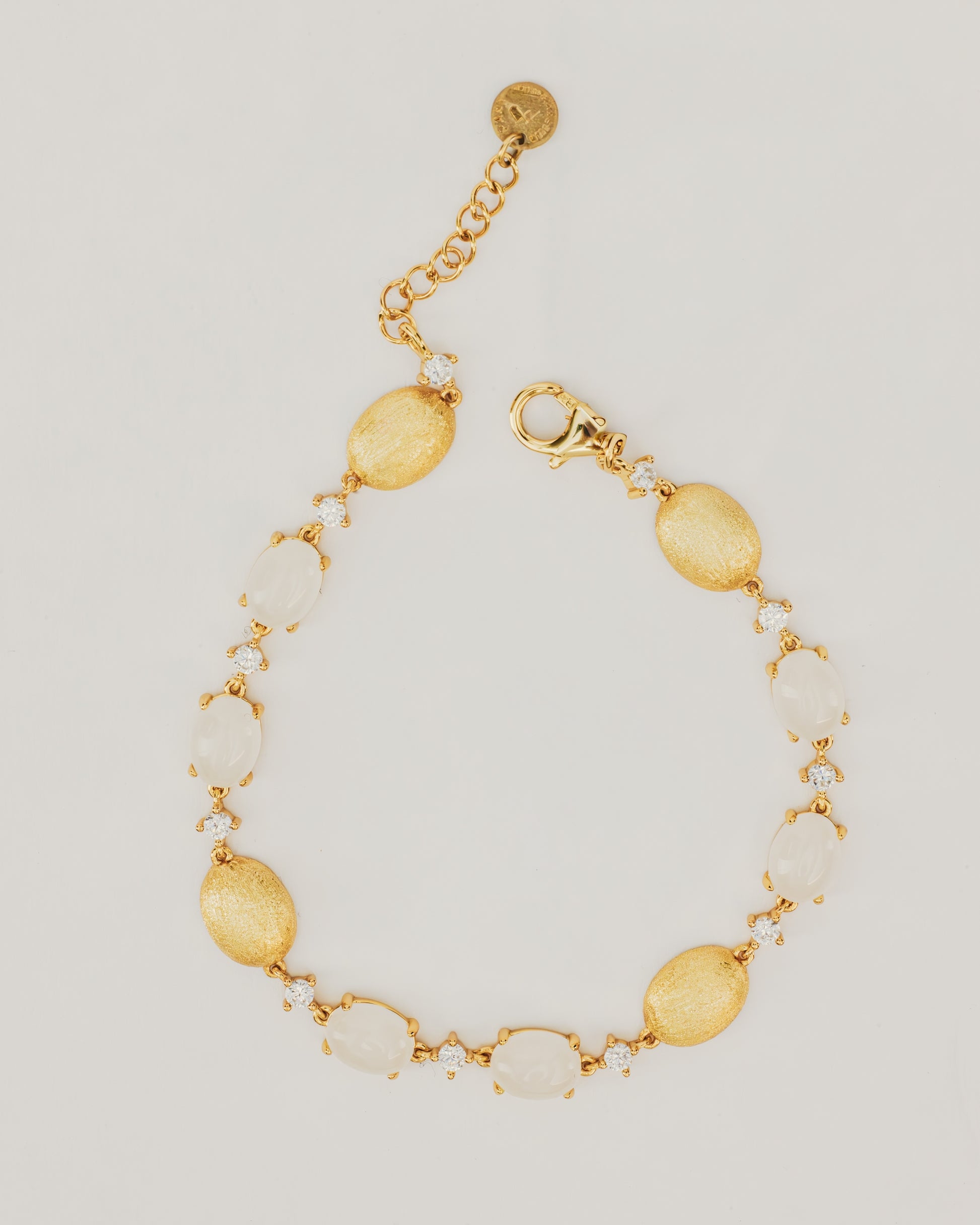 Bracciale Dorato con Pietre Cabochon Bianche e Dettagli Luminosi
