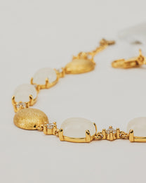 Bracciale Dorato con Pietre Cabochon Bianche e Dettagli Luminosi