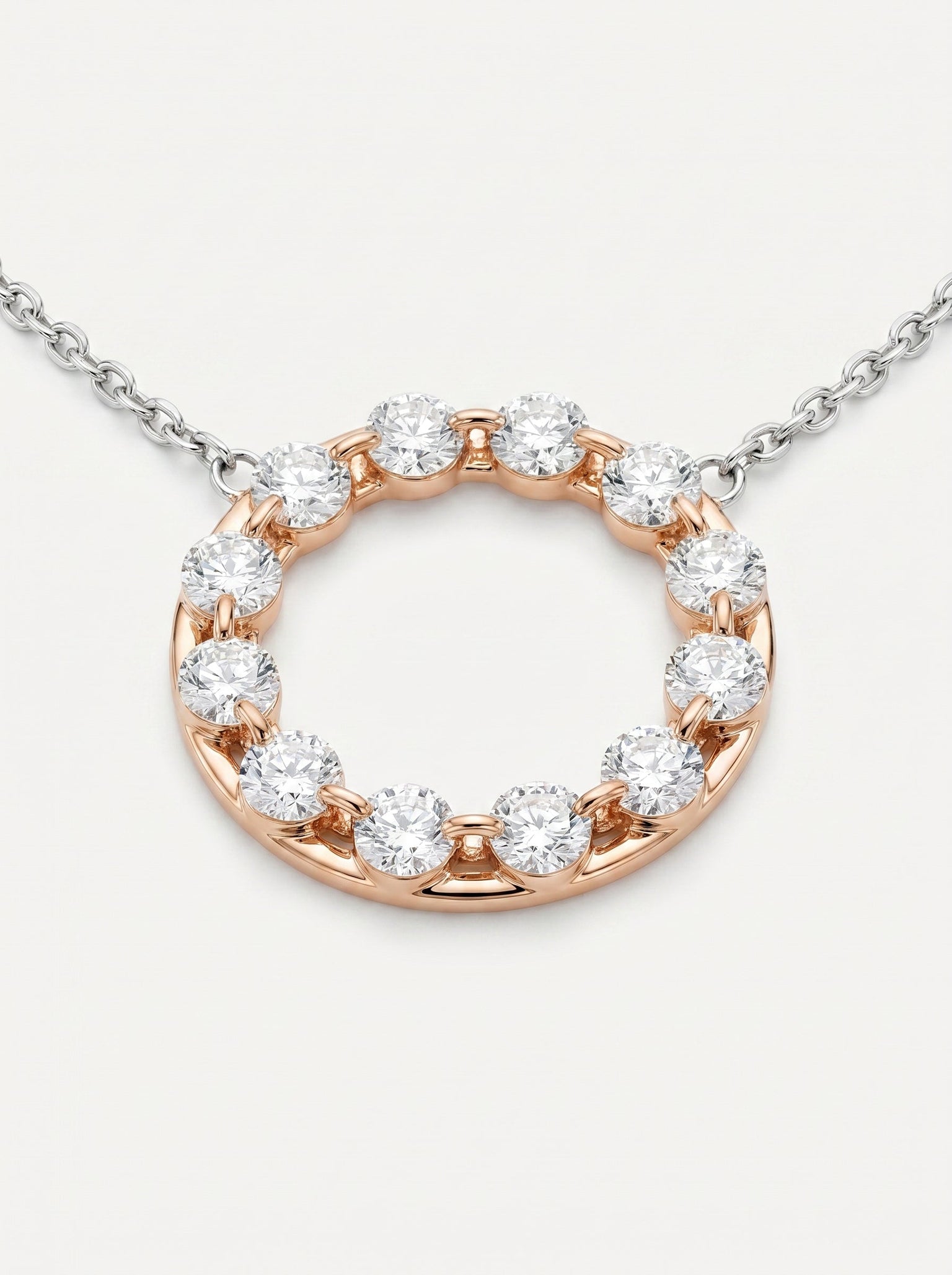 Dettaglio pendente circolare in oro bianco e rosa con diamanti